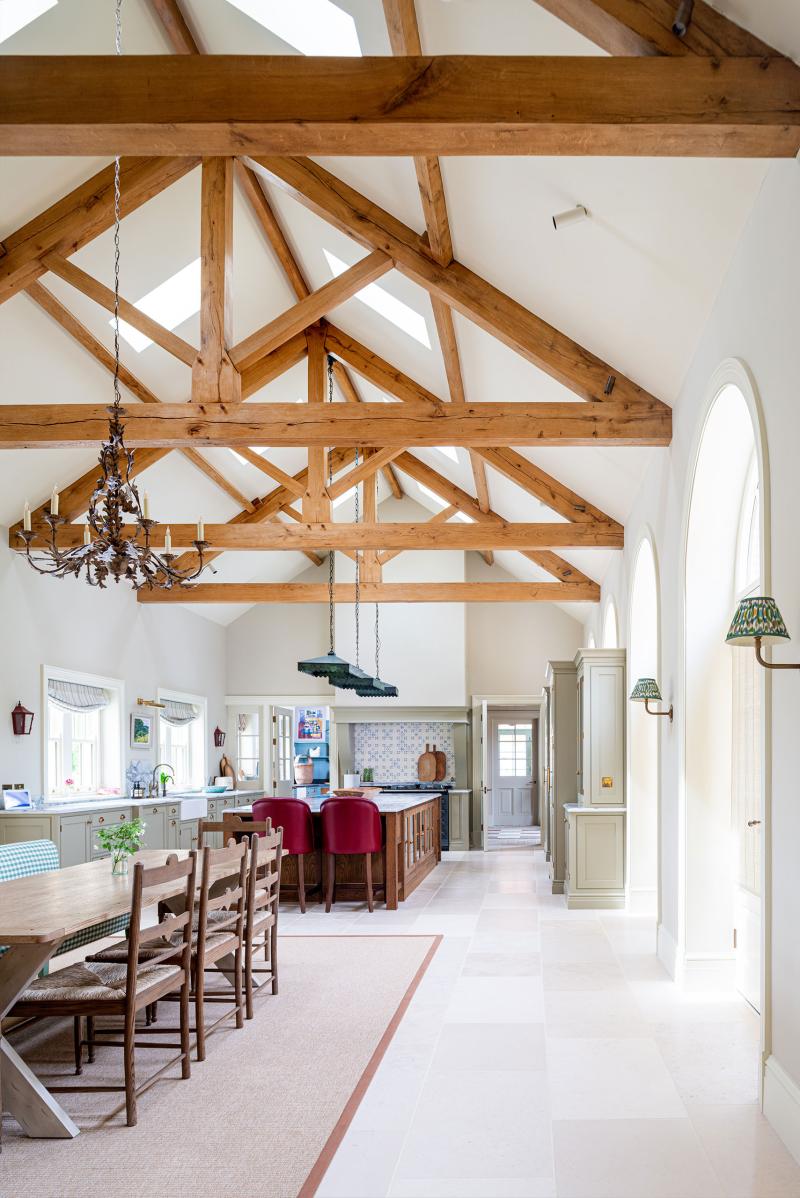 Vaulted kitchen-diner with exposed oak roof trusses, wrought-iron chandelier and long dining table